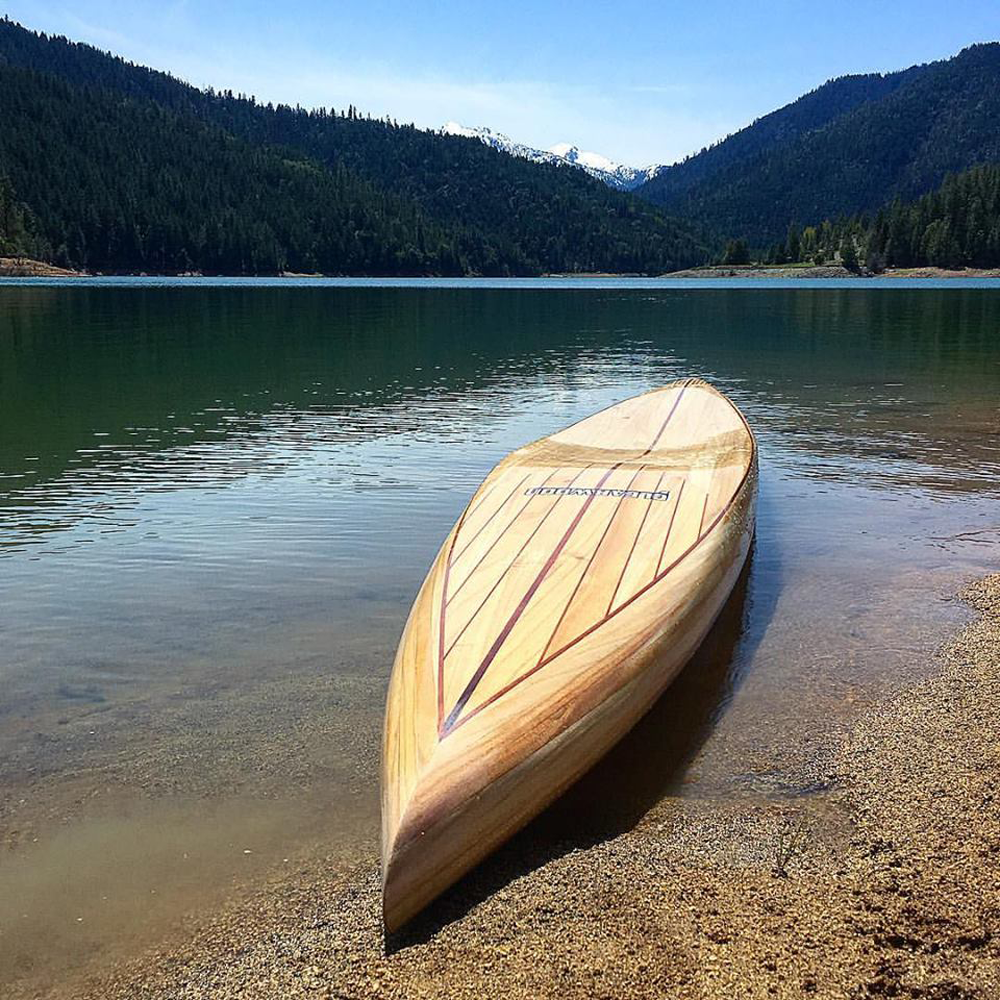 wooden prone paddleboard on a lake